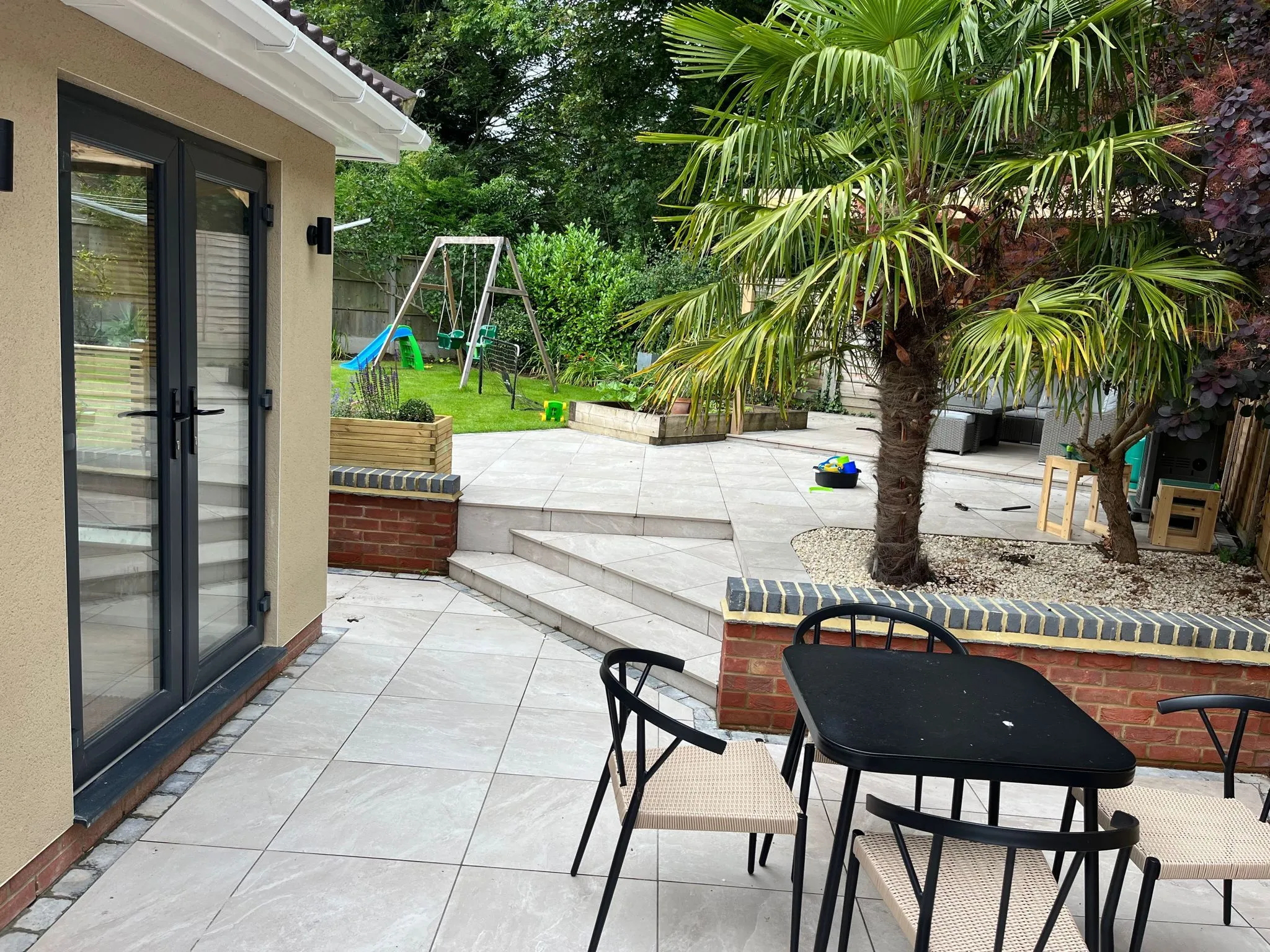a patio with a table and chairs next to a tree